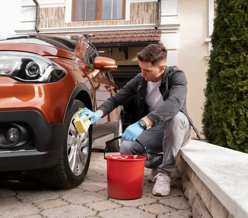 Lavage auto à domicile Quatre-Champs : professionnel intervenant sur un véhicule
